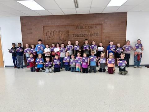 Elementary students showing off their new book.