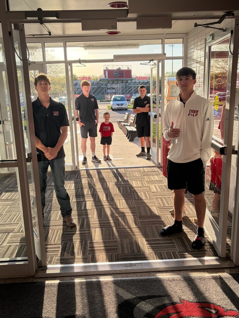 four golfers greeting an elementary students