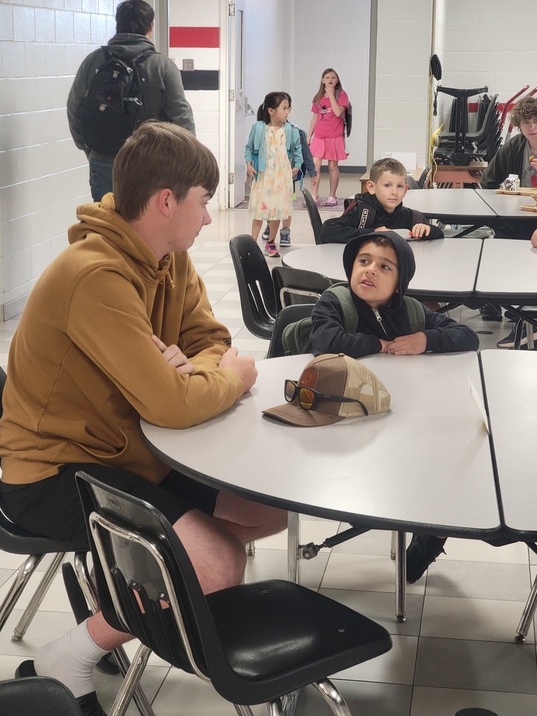 senior golfer visiting with an elementary student