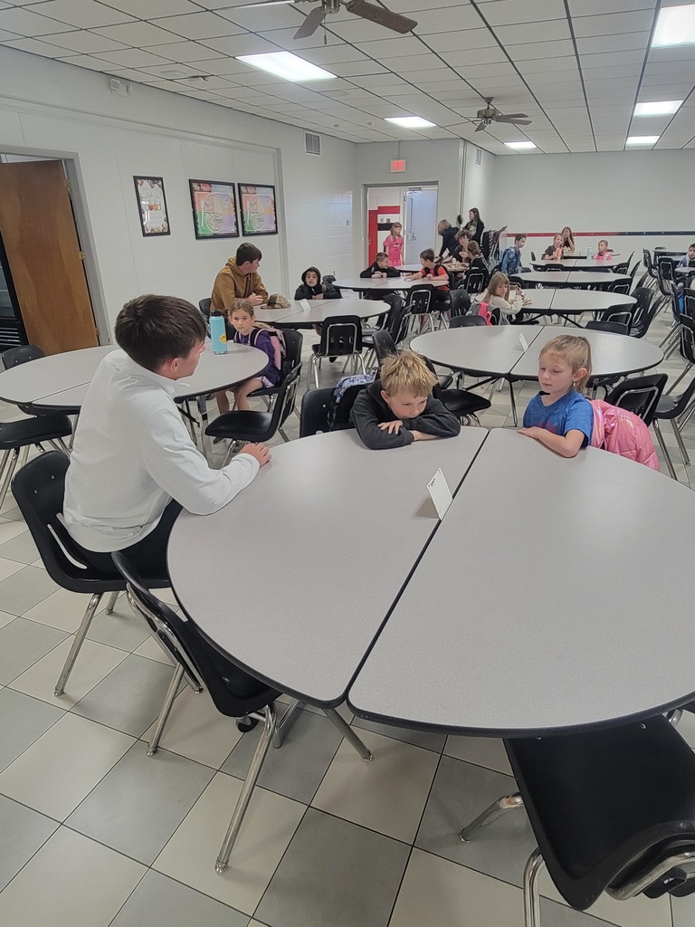 senior golfer visiting with two elementary students