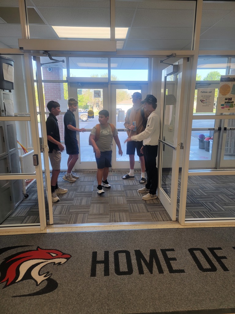 four golfers greeting an elementary student