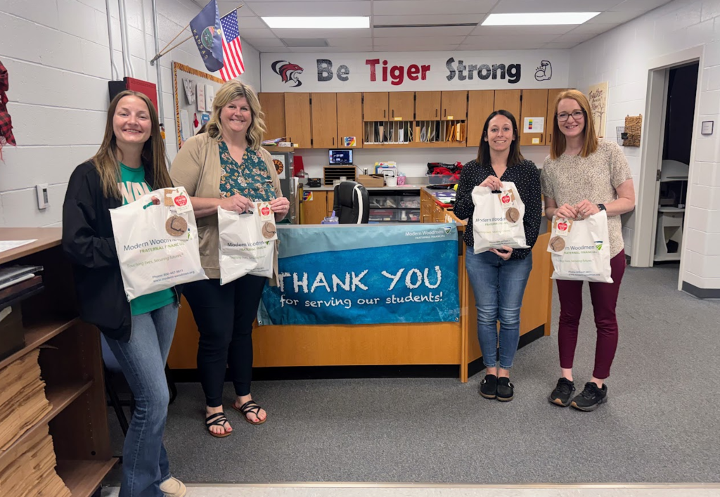 four staff members holding treat bags