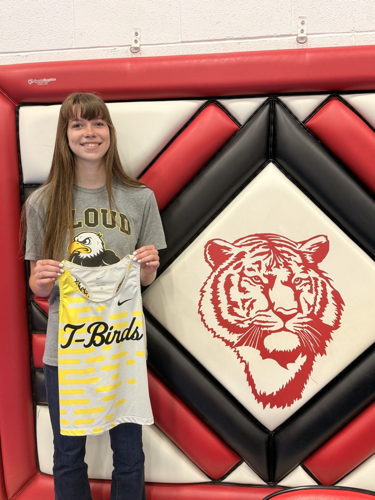 Washington County Tiger Alyssa Jueneman holding a Cloud County Track jersey to celebrate her signing with CCCC