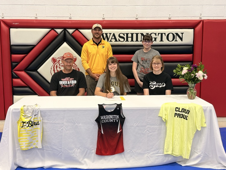 Alyssa Jueneman celebrates her signing with Cloud County posing with WCHS track coach, CCCC track coach and her mother and sister