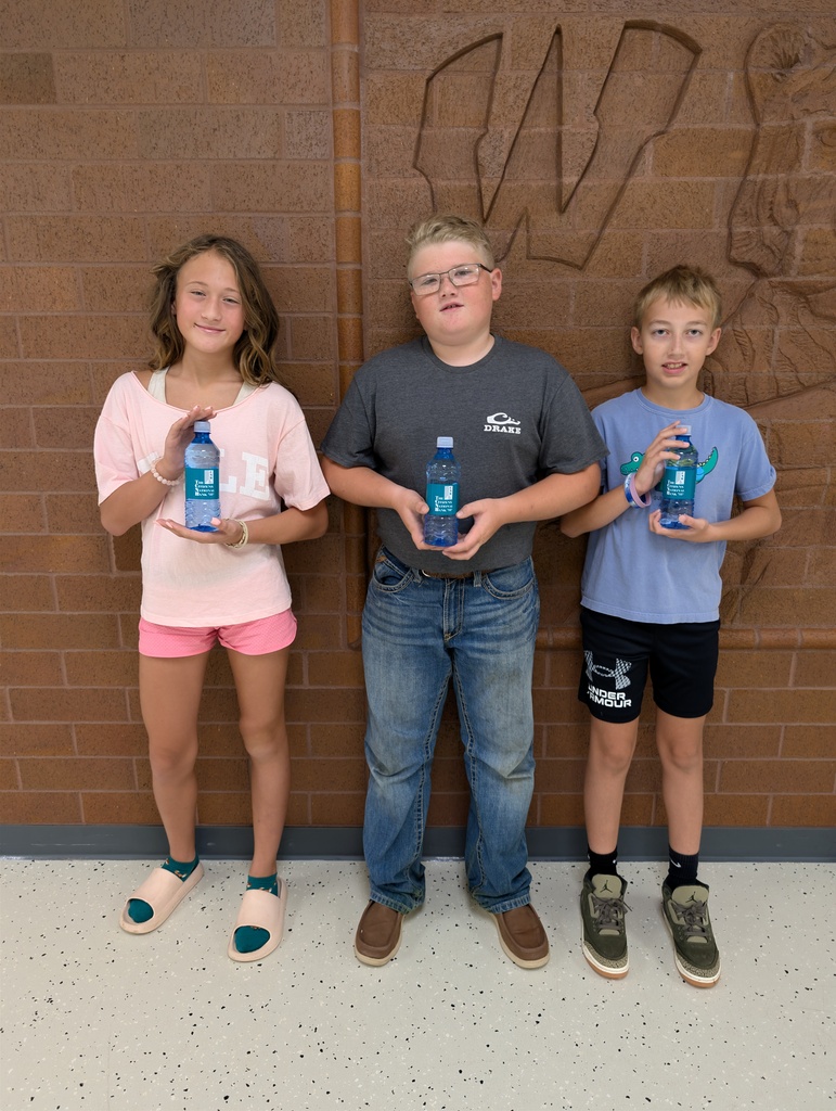 three students holding water bottles from Citzens National Bank.