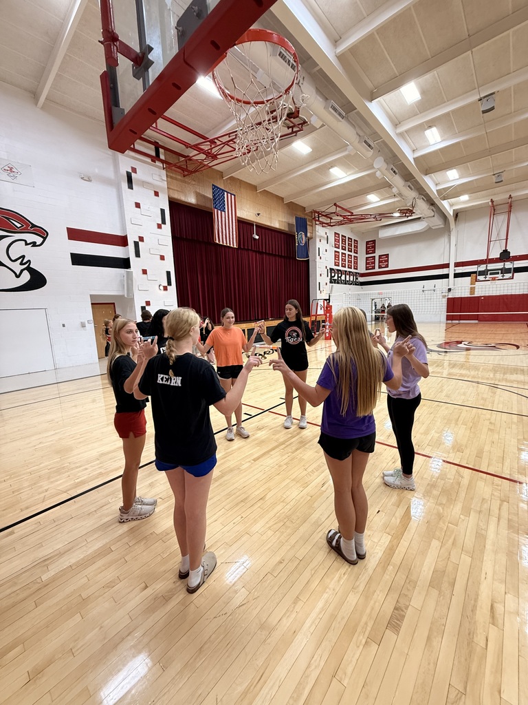 HS Volleyball players in a circle holding expo markers between their index fingers in a race against other team representatives.