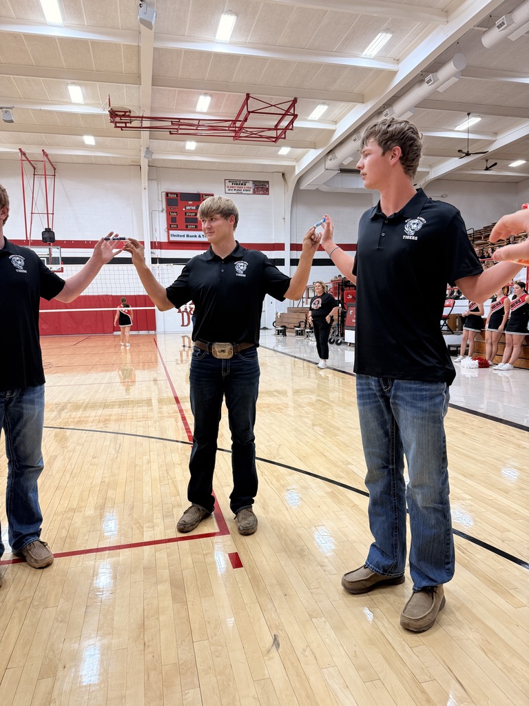 HS Football Players in a circle holding expo markers between their index fingers in a race against other team representatives.