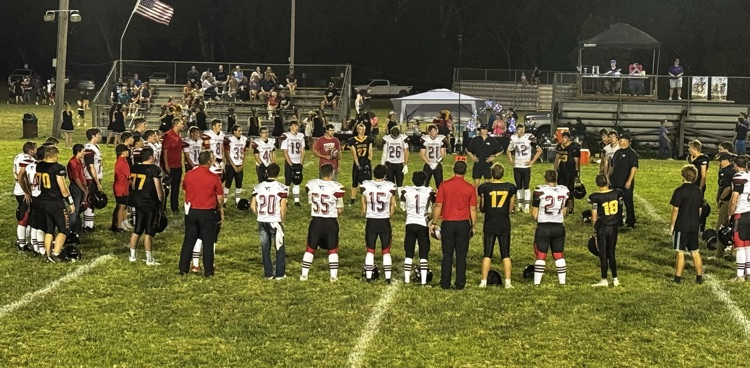 The Tiger football teams joins their opponent for a postgame prayer