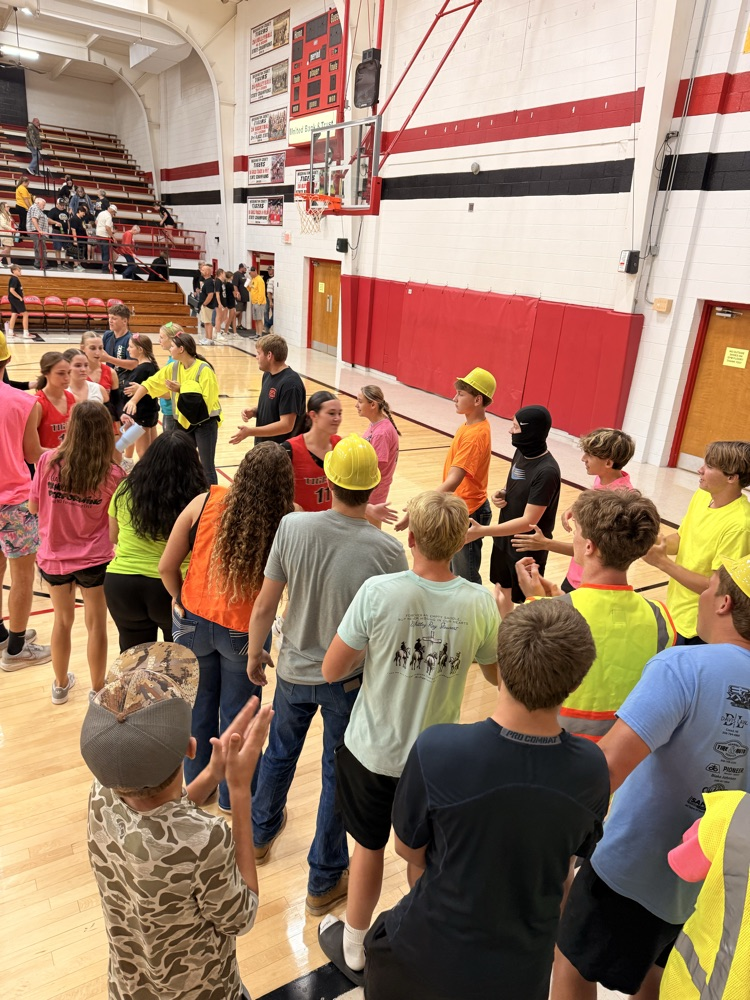 the students form a tunnel to high five the girls on the way to their locker room  