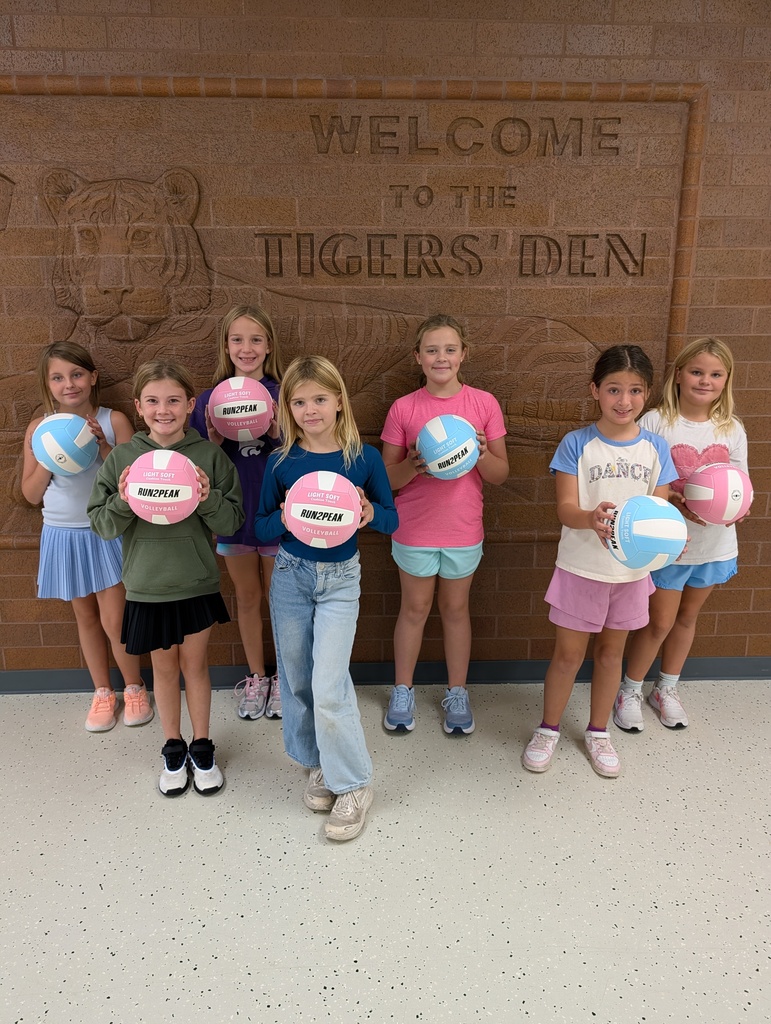 fourth grade students holding volleyballs