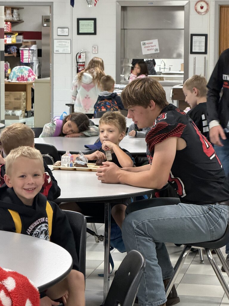 homecoming candidates talking with elementary students in the cafeteria