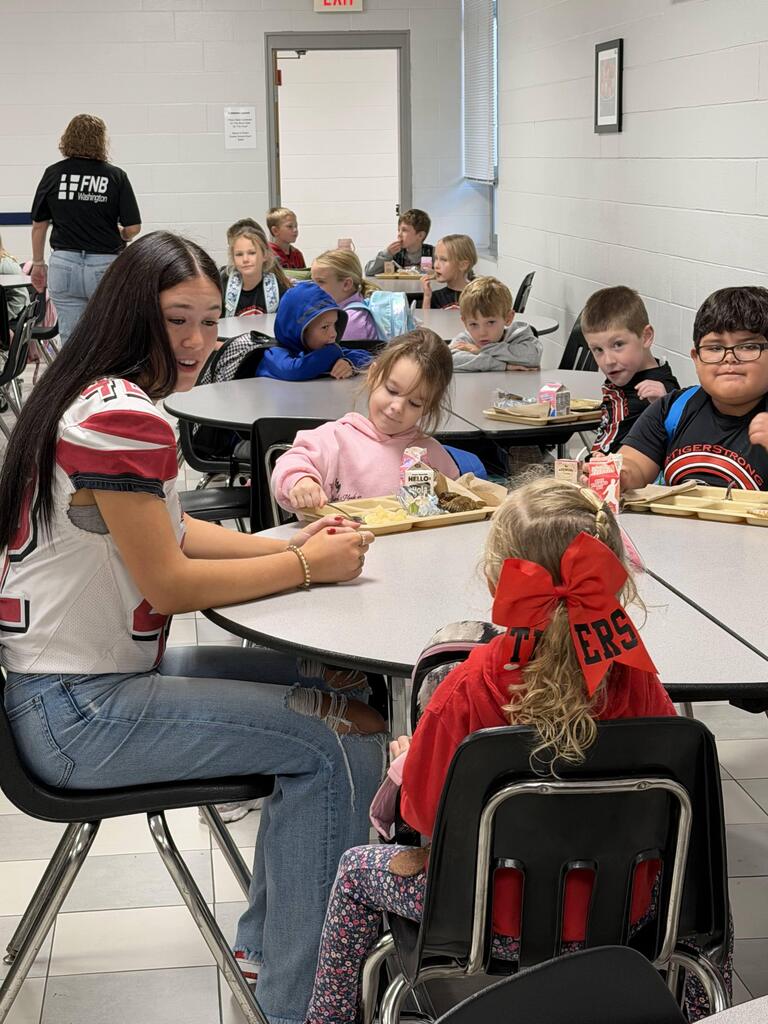 homecoming candidates talking with elementary students in the cafeteria