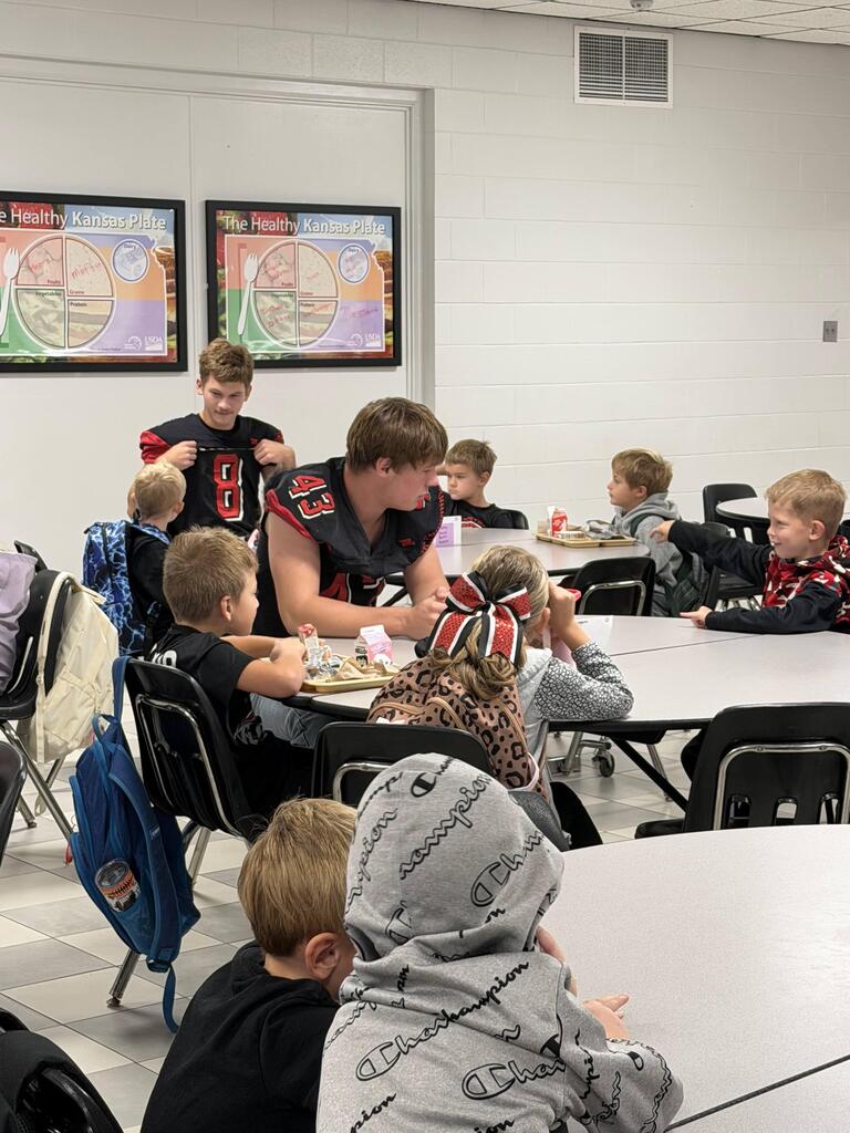 homecoming candidates talking with elementary students in the cafeteria