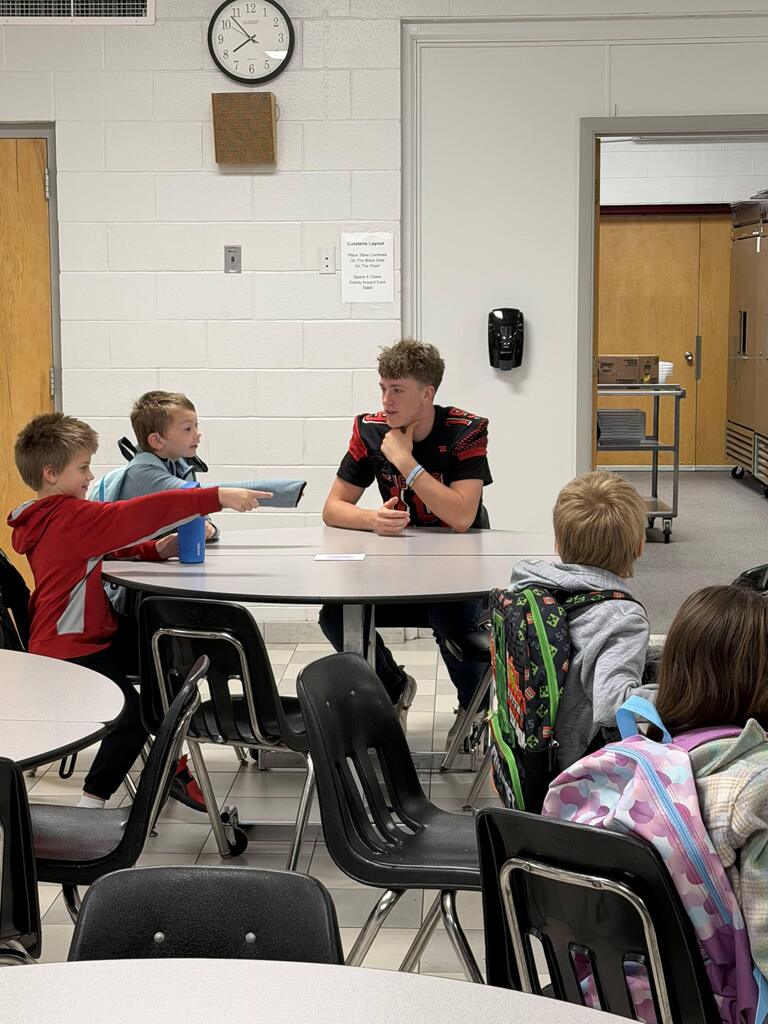 homecoming candidates talking with elementary students in the cafeteria