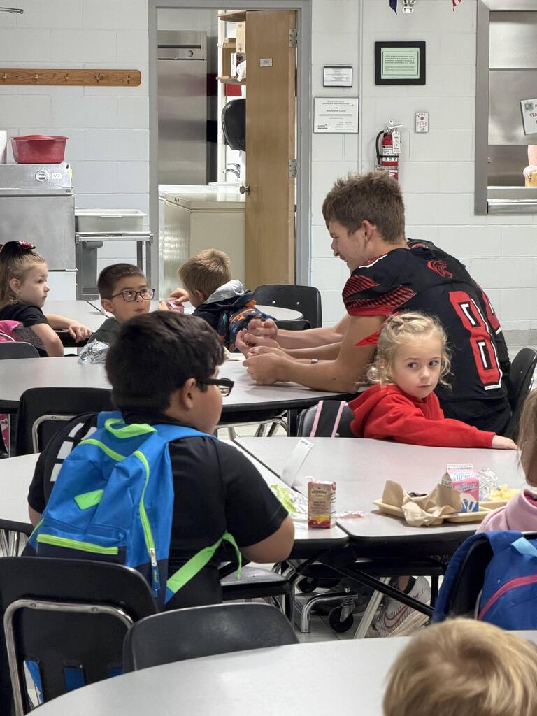 homecoming candidates talking with elementary students in the cafeteria