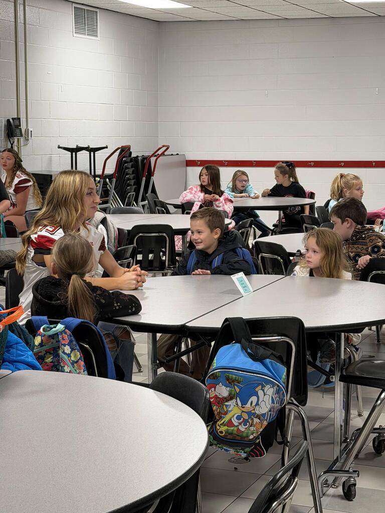homecoming candidates talking with elementary students in the cafeteria