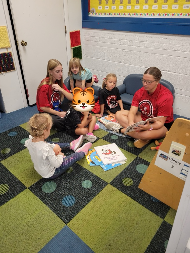 Homecoming candidates reading to preschool students. 