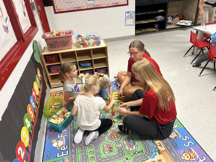 Homecoming candidates playing with our 3 year old preschoolers