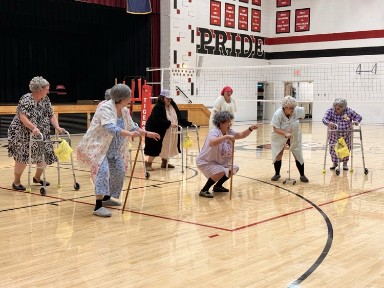 Senior moms dressed as senior citizens dancing at the pep rally  