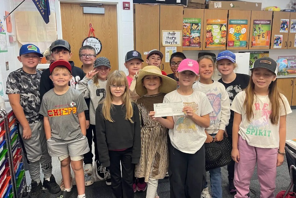 Mrs. Mintzmyer's third grade class holdng a check