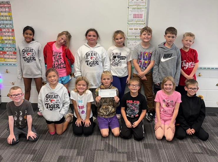 Mrs. Nelson's third grade class holdng a check