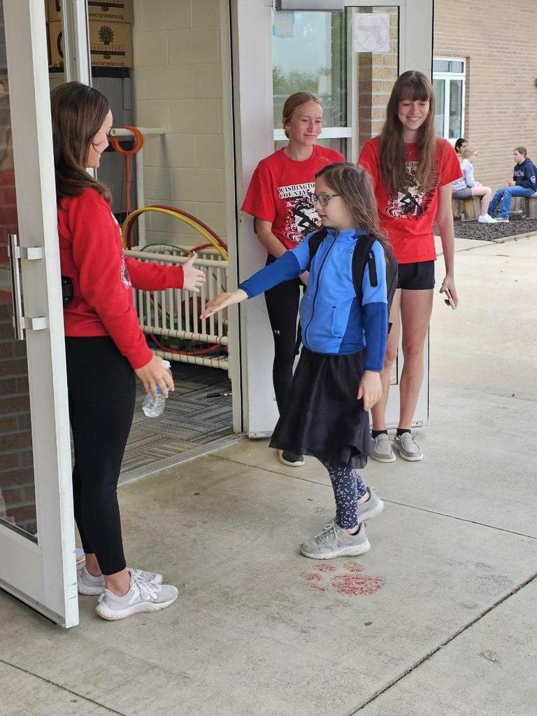 track and golf athletes greeting and playing with elementary students