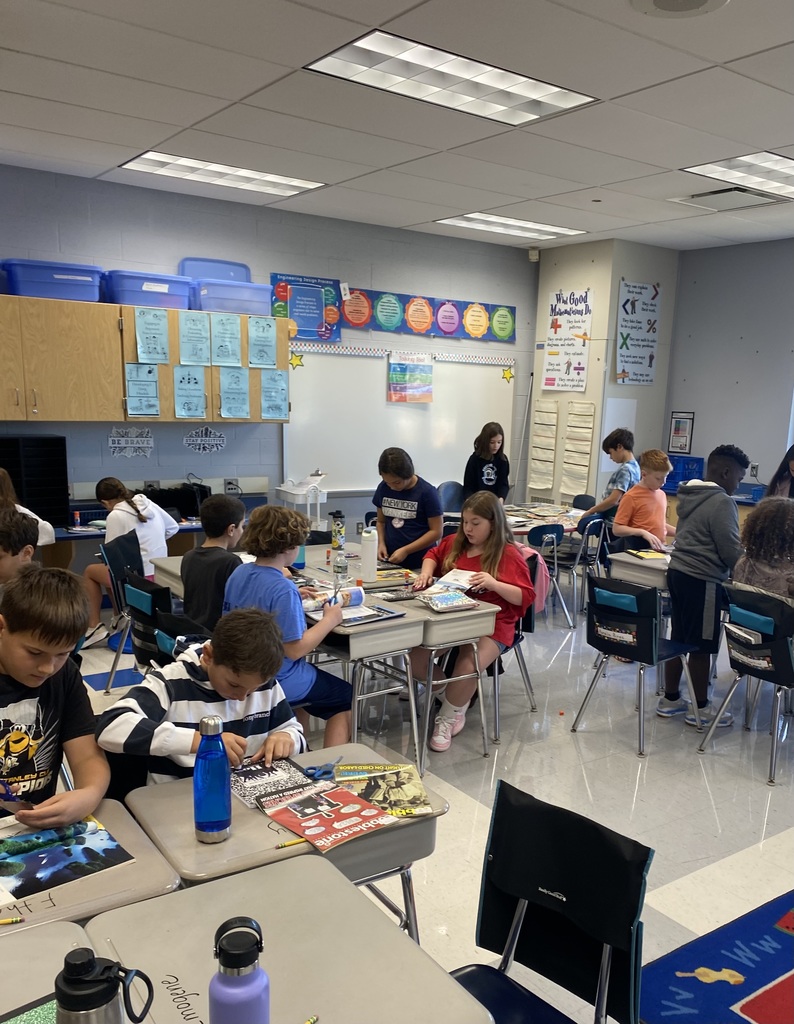 5th-grade students in Mrs. Jones and Mrs. Leonard's class cut out photographs from scientific magazines to decorate their science journals.  