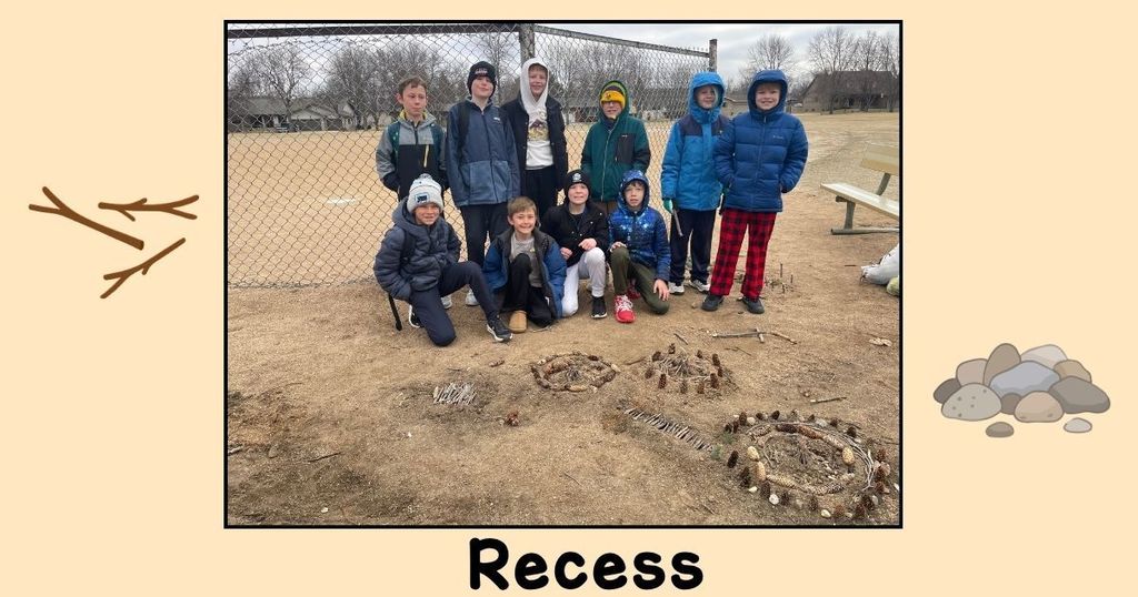 A group of 4th grade students proudly stand near a small village they created out of sticks, including tiny structures arranged on the ground.