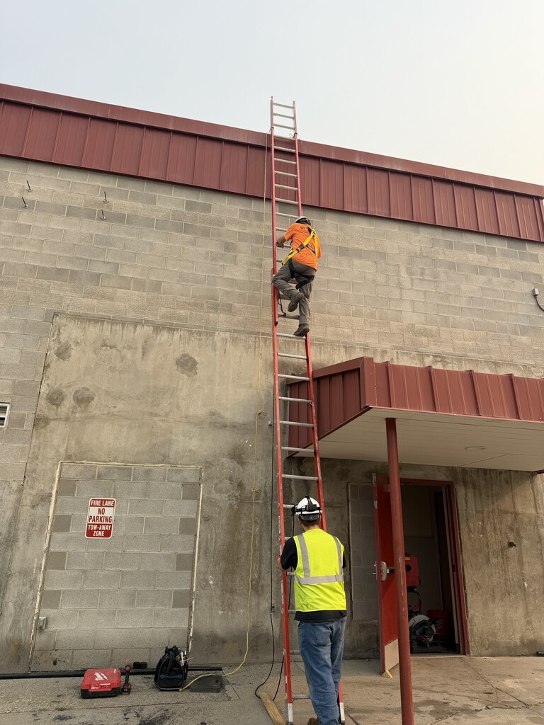 Construction worker going up a ladder.