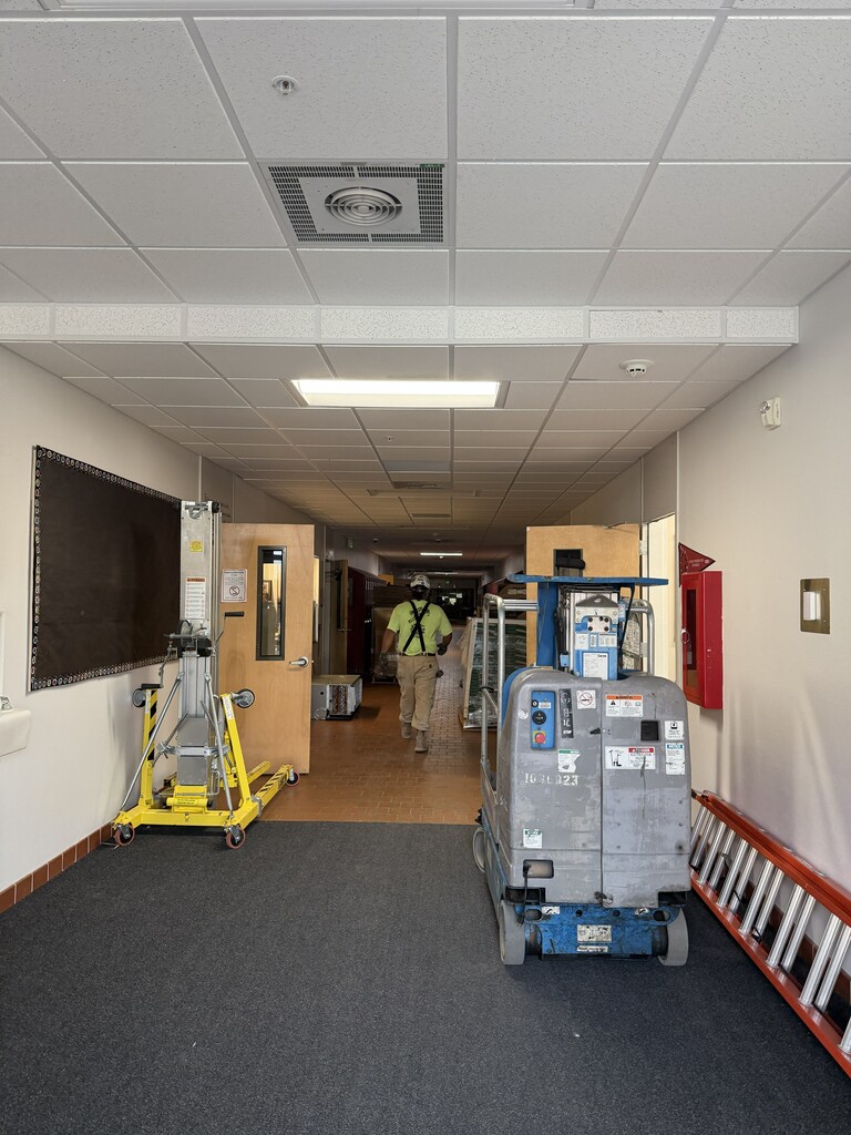 Construction worker walking through the JR High hallway..