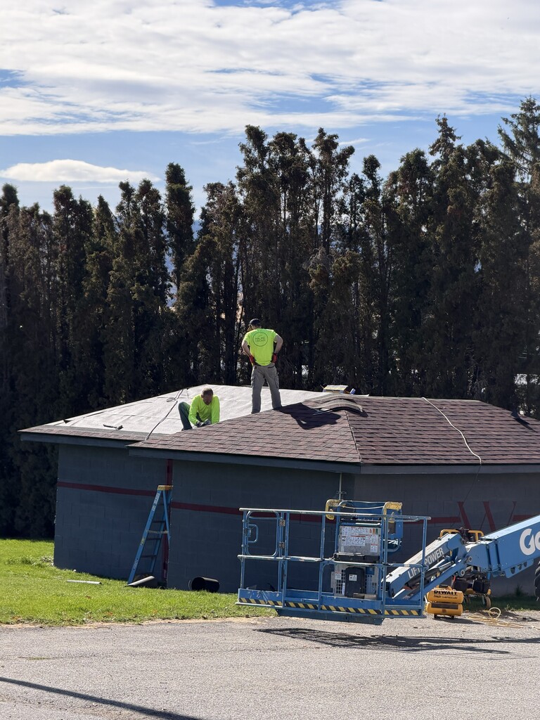 Two workers working on a shed roof.