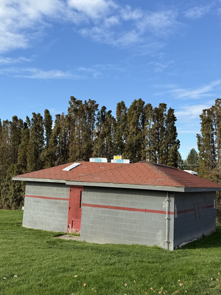 Gray shed with brown roof.