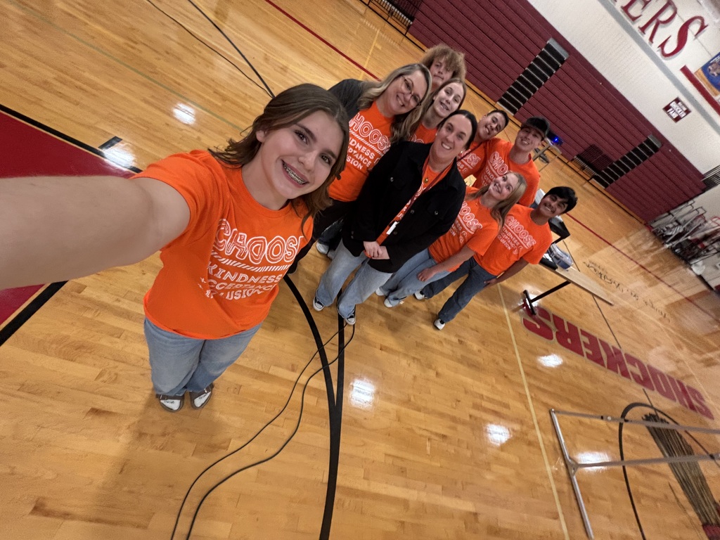 Students in gym with orange shirts.
