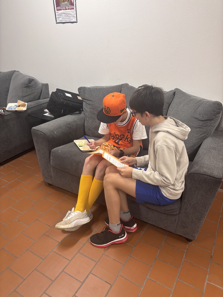 Students reading on a gray couch.