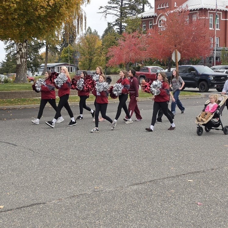 Cheerleaders cheering down a street