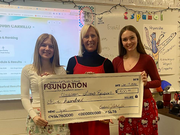 Teacher and students holding large check