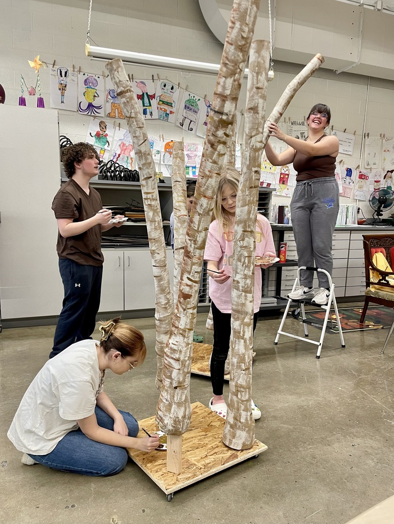 students making giant trees sculptures out of cardboard and paper