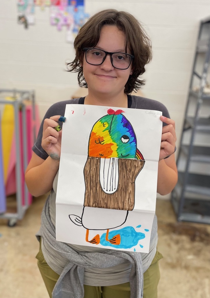 female student holding her paper drawing