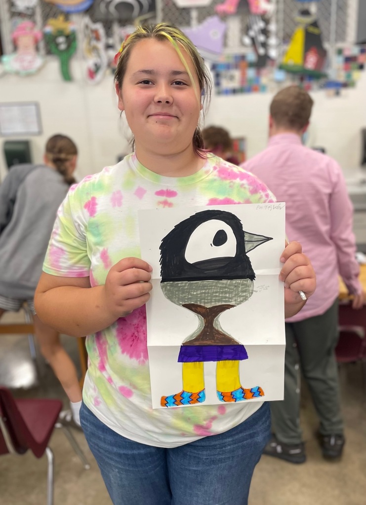 famale student showing her folded paper drawing