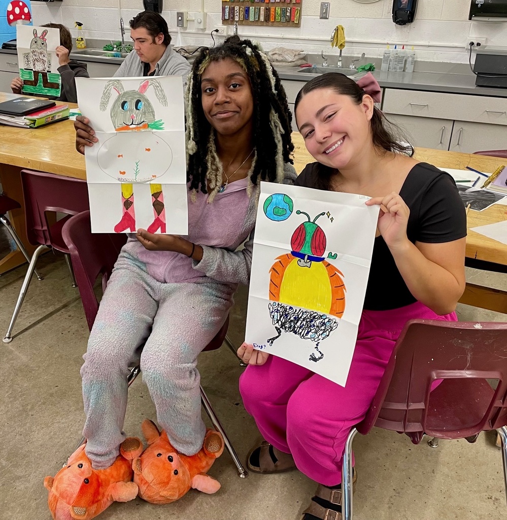 female students showing their folded paper drawings