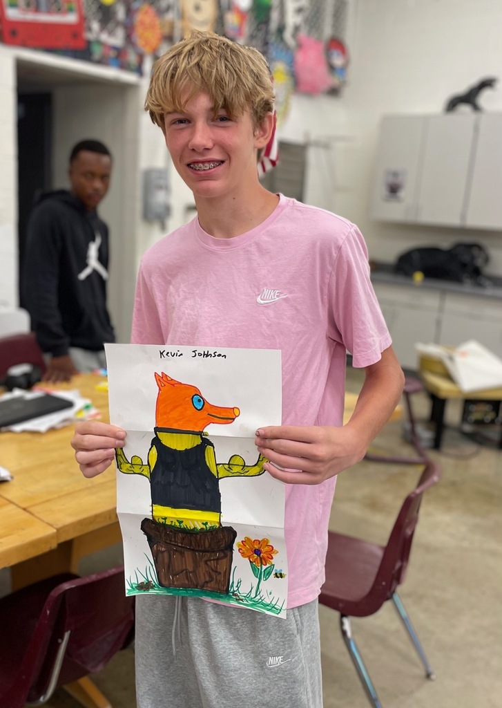 male student showing his folded paper drawing