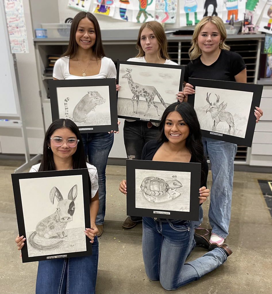 Girls holding their pencil drawings