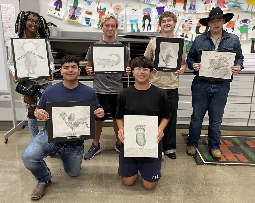 Students holding their animal pencil drawings 
