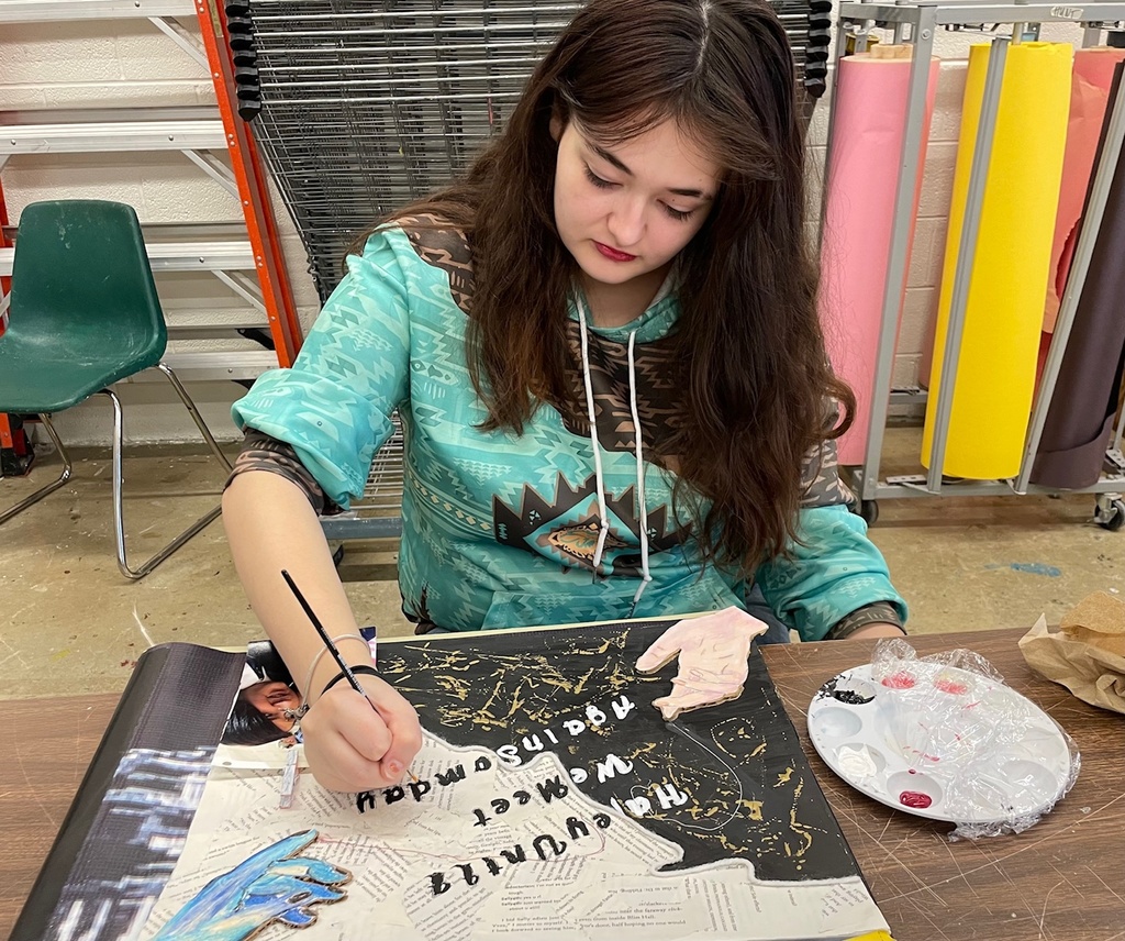 student painting her 6 words piece