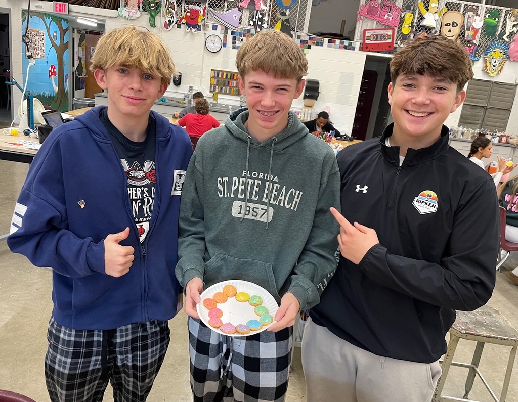 students holding their color wheel made out of frosting on vanilla wafers