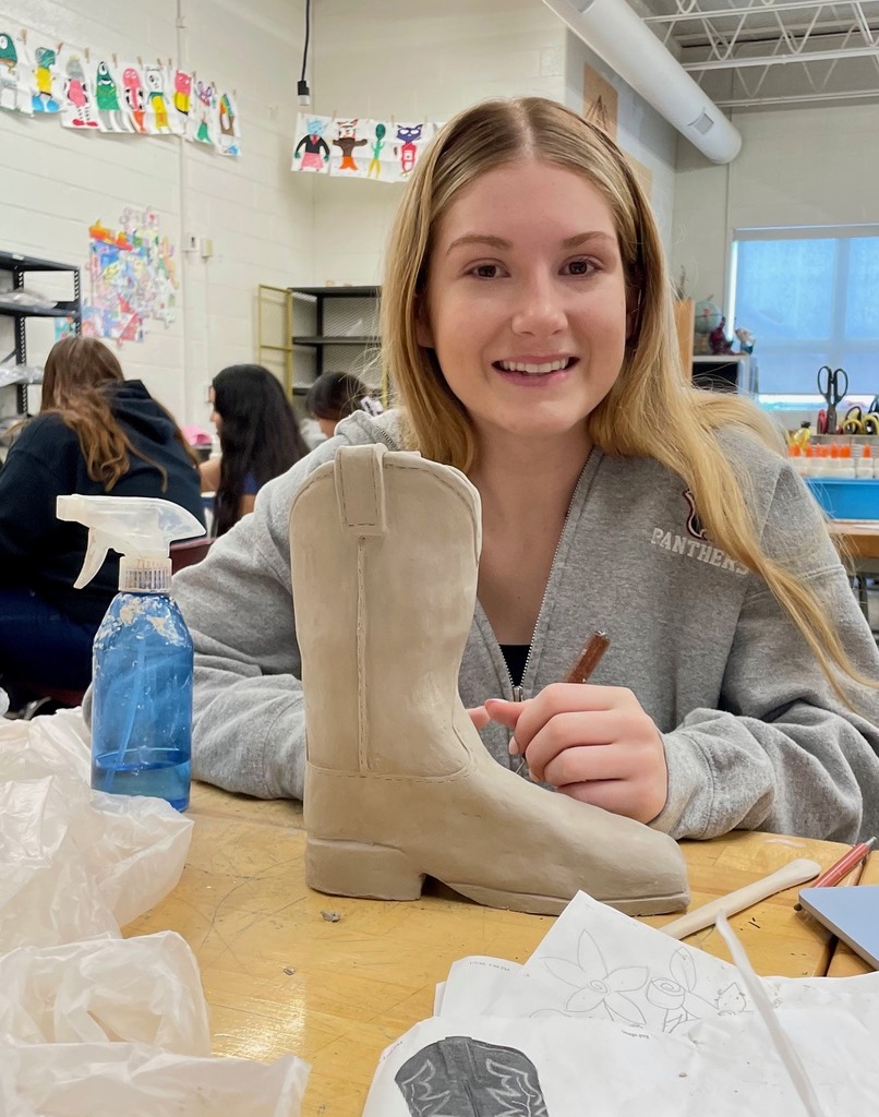 female student working on clay cowboy boot project 