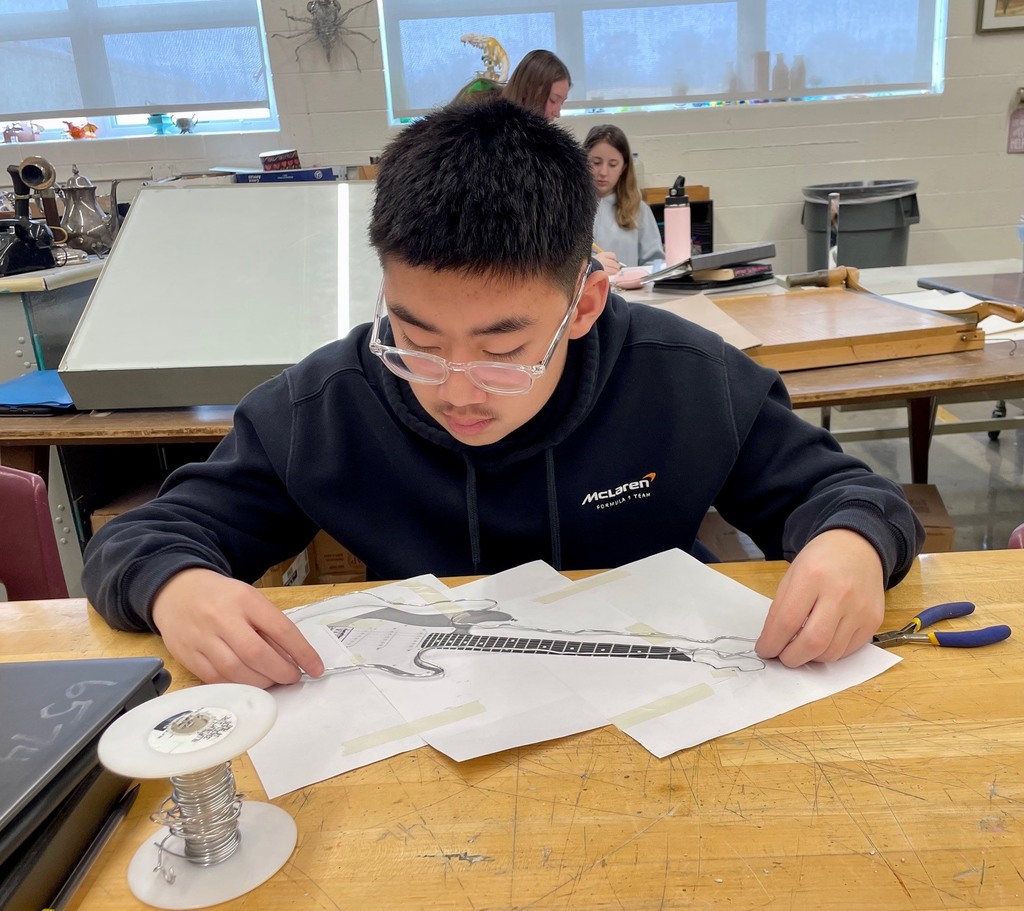 male student working on his wire guitar  project 