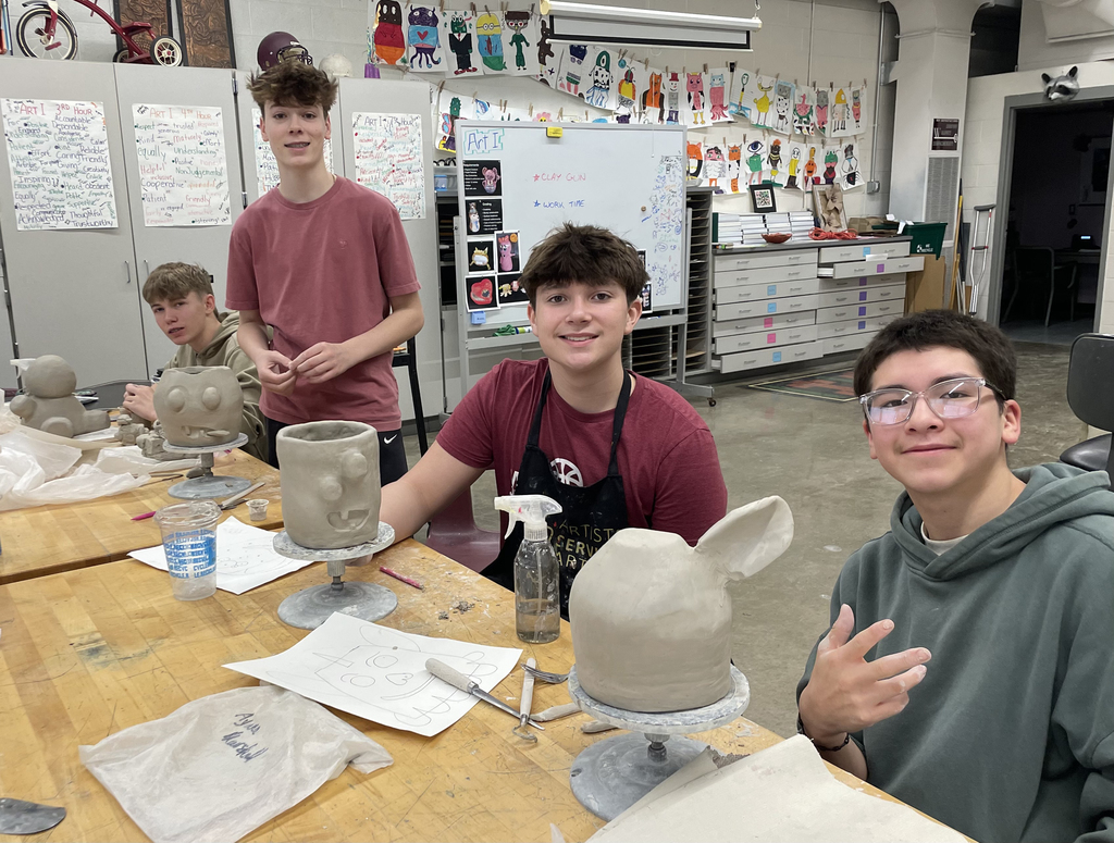4 male students working on their clay projects