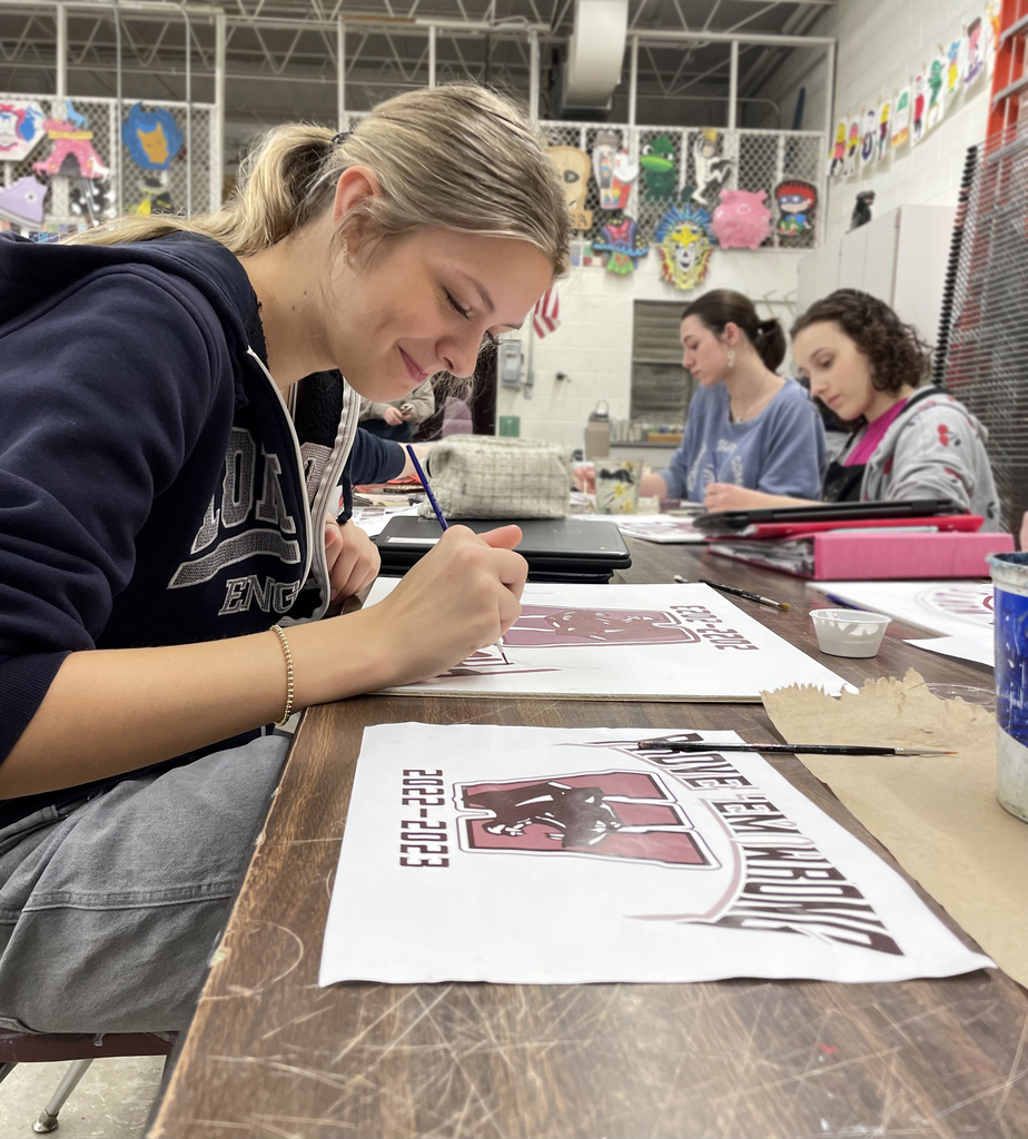 female student painting mural motto