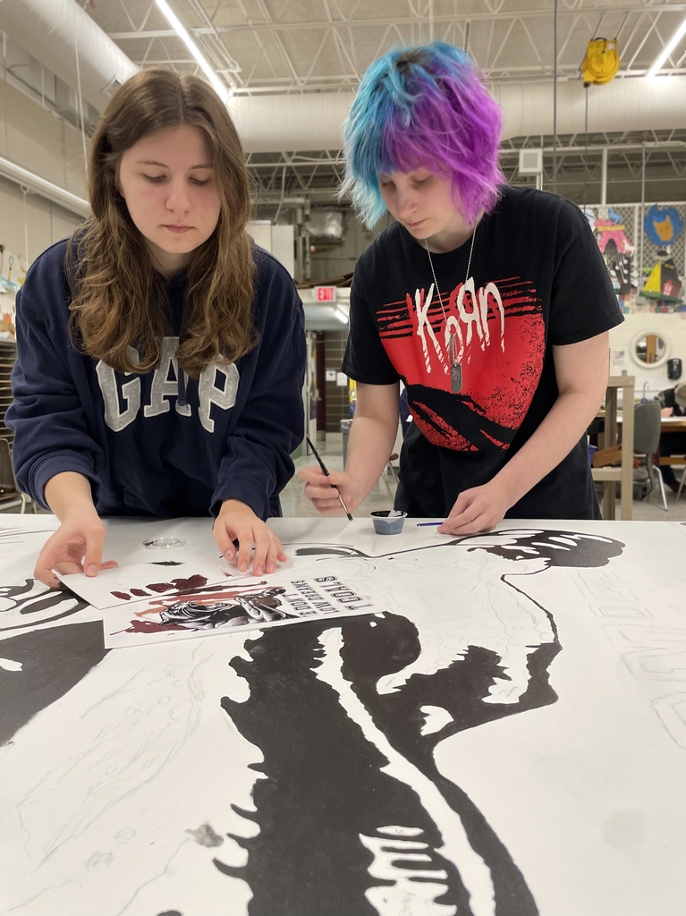 femaile students painting wall mural